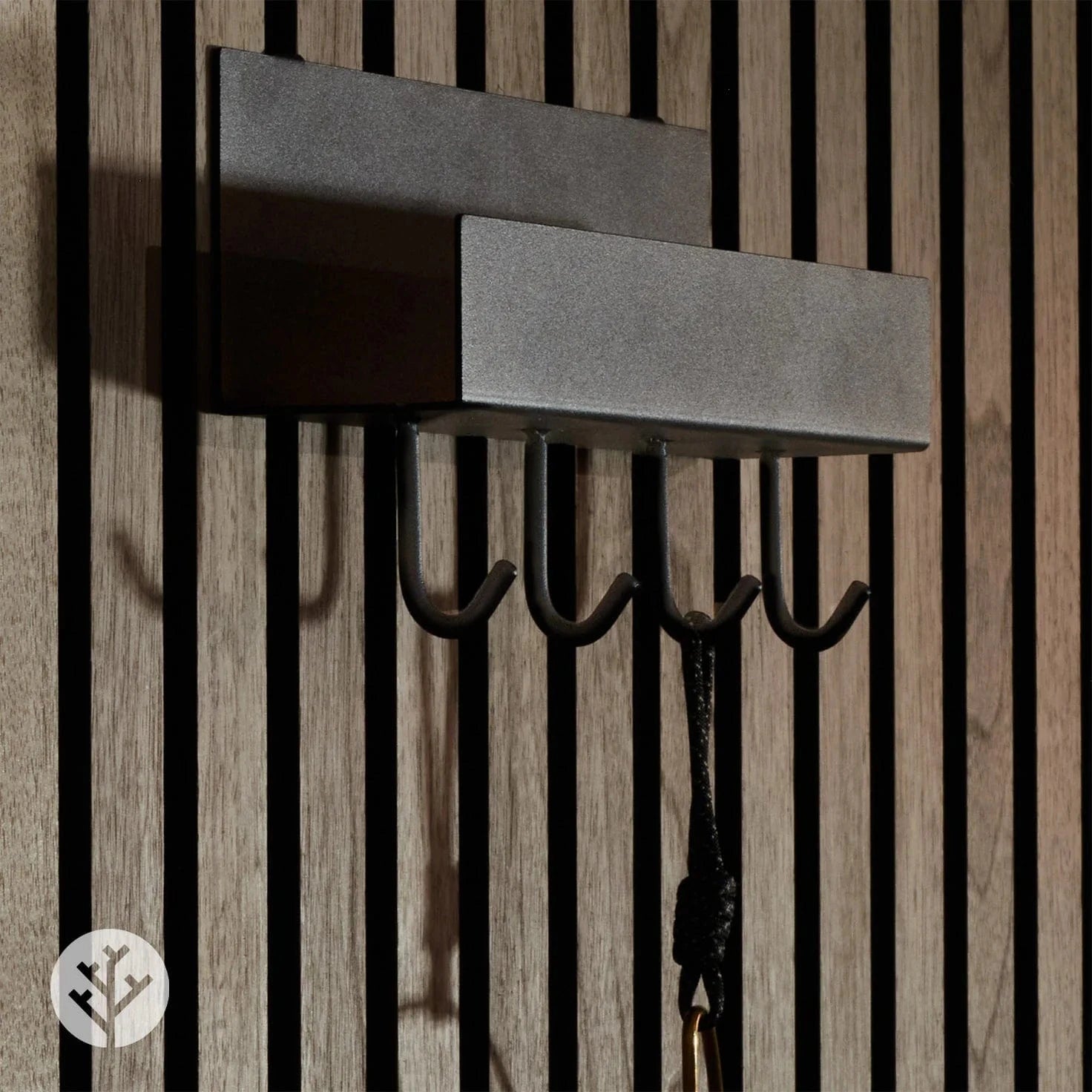 Close-up of shelf with hooks showing matte black powder-coated steel finish and hook profile