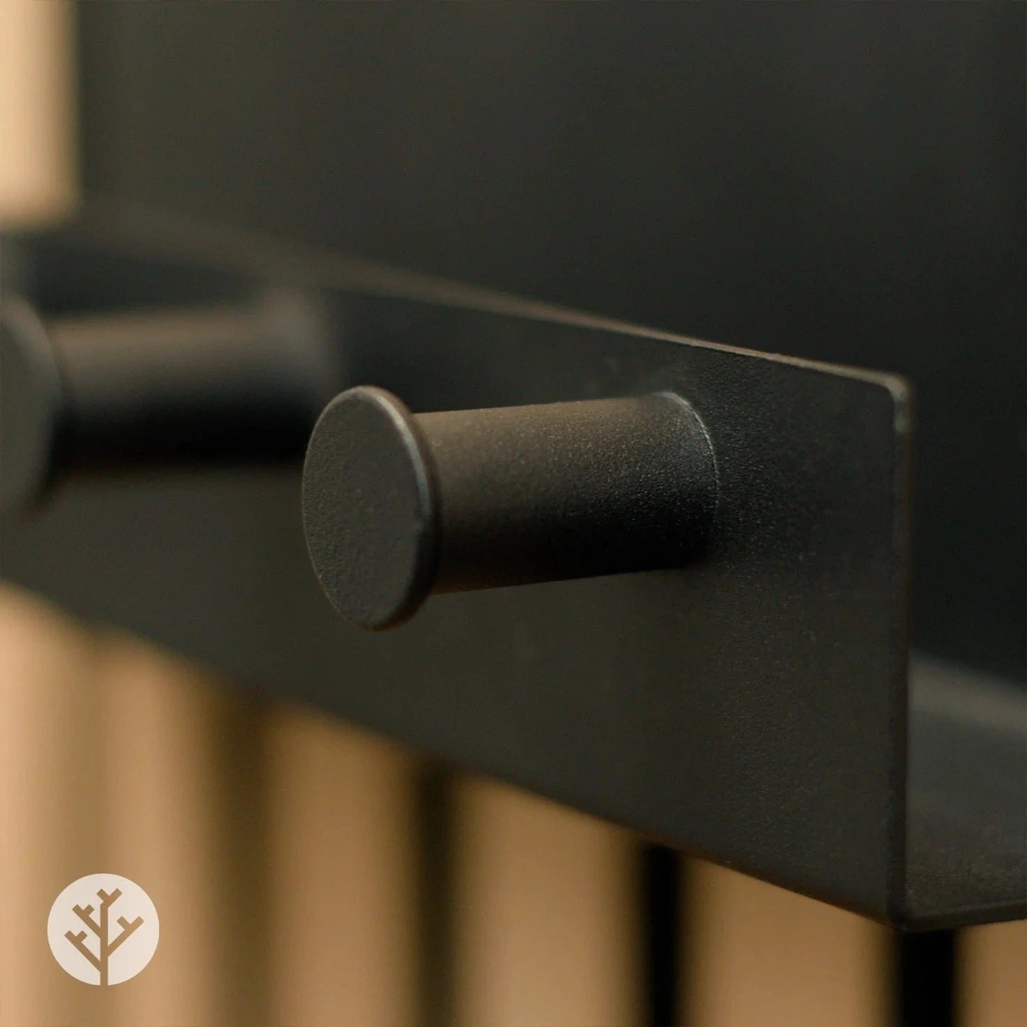 Close-up of shelf with pegs showing matte black finish and rounded peg profile detail