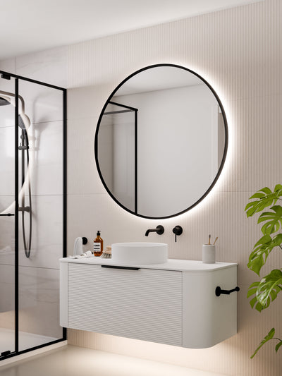 Aura round mirror installed in modern bathroom above vanity basin with LED backlighting