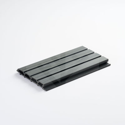 Close-up of Plaank walnut sample piece showing dark wood-effect composite grain finish