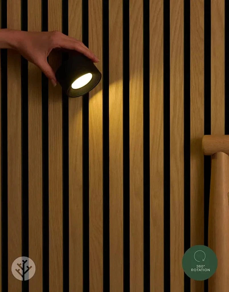 Close-up of Acupanel Glow beam light showing matte black cylinder mounted between oak slats