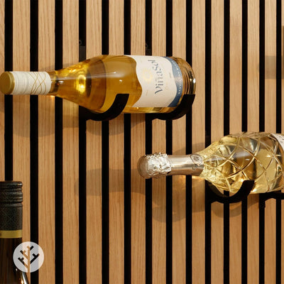 Black wine rack holding bottle between oak Acupanel slats with warm lighting and decor nearby