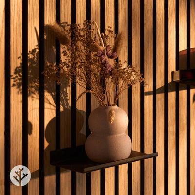 Black small ledge shelf on walnut Acupanel wall with ceramic vases and dried pampas grass