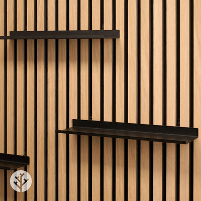 Large ledge shelf in living room holding plants and frames creating curated wall display