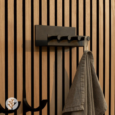 Shelf with pegs installed on walnut Acupanel in bathroom holding towels and grooming items
