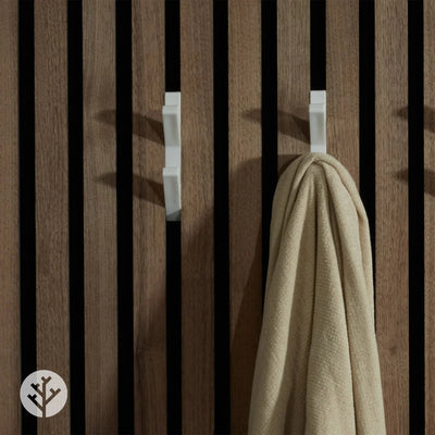 Close-up of empty white 3D hooks mounted between natural oak Acupanel slats showing profile